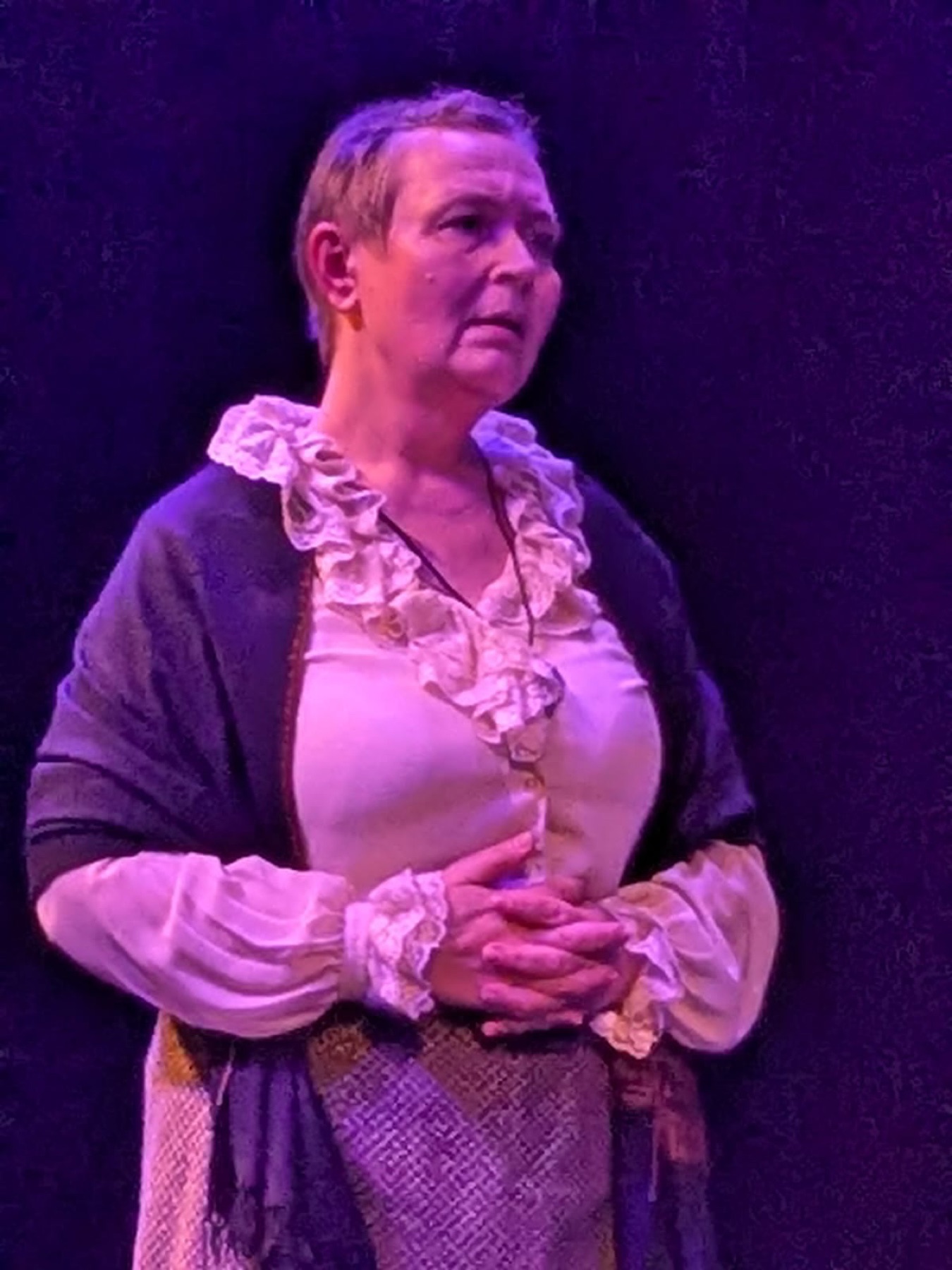 A performer held in purple light
