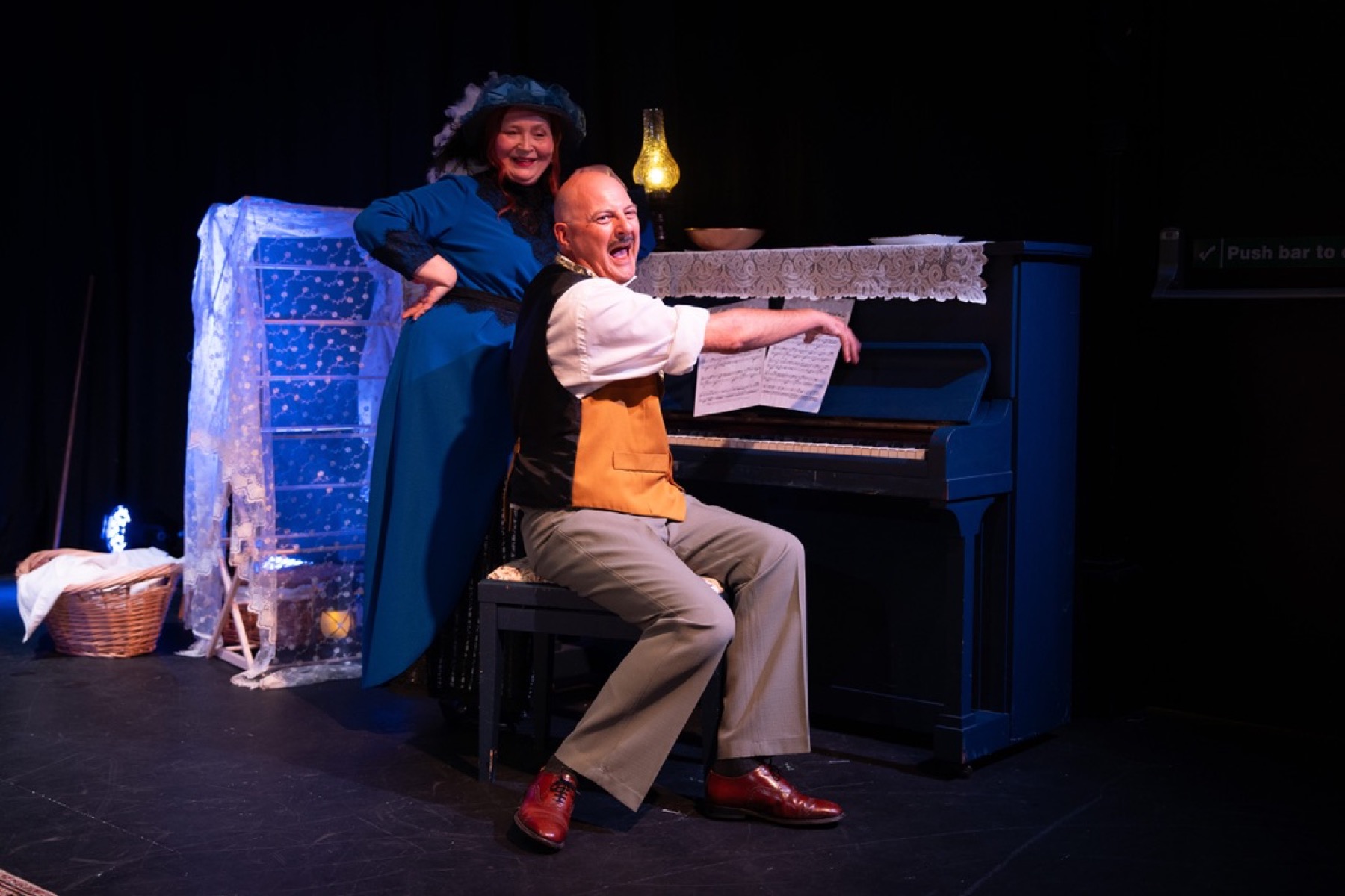 A figure in blue confronting another performer
